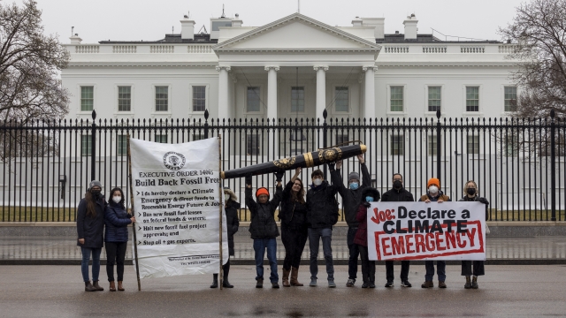 Organizers with the Build Back Fossil Free campaign stand in front of the White House.