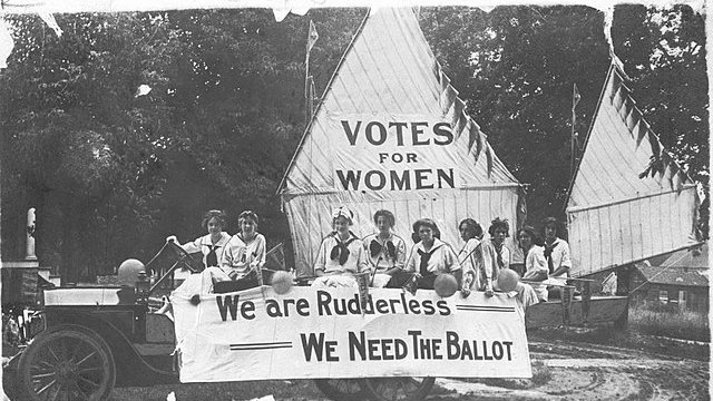 An old photo shows women campaigning for the right to vote.
