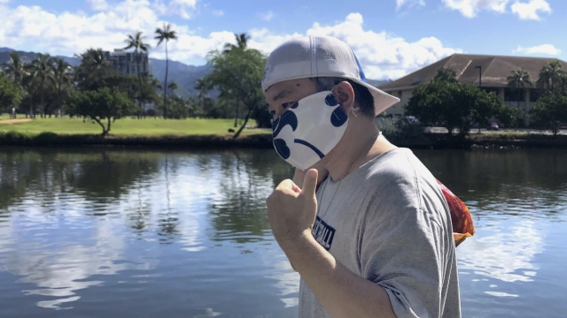 A man wearing an aloha print mask
