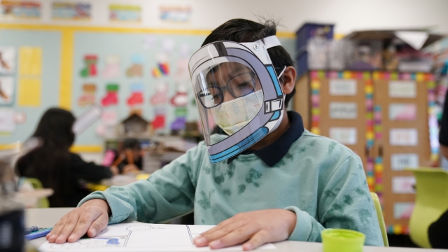 A student wears a mask and face shield in a 4th grade class amid the COVID-19 pandemic