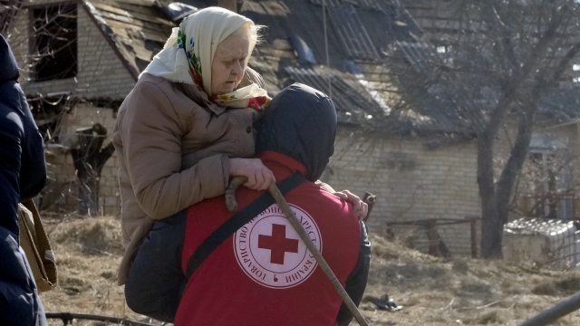 A Red Cross worker carries an elderly women during evacuation