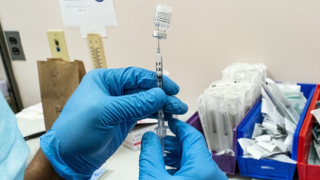 A pharmacist prepares a syringe with Pfizer’s vaccine