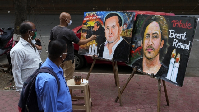 A person makes a painting of Brent Renaud.