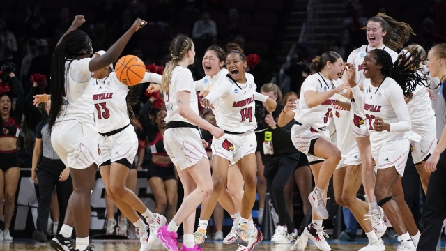Louisville women's basketball players celebrate a win after a college basketball game in the Elite 8 round