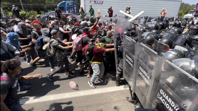 Migrants break through a line of National Guard troops trying to block them from leaving Tapachula, Mexico.