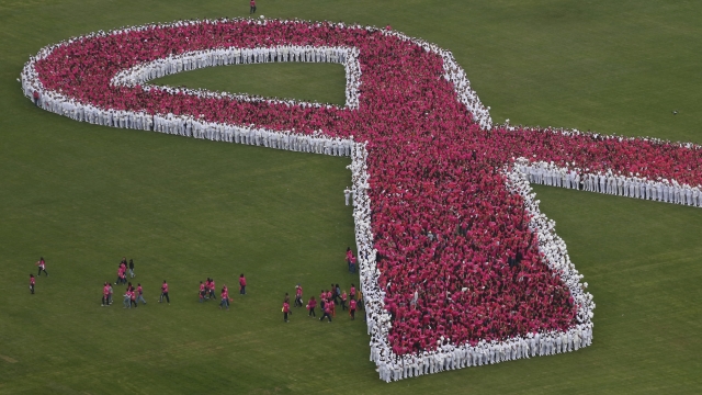 Participants form a giant pink ribbon to mark the start of breast cancer awareness month
