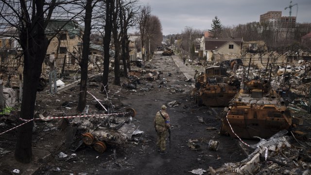 A Ukrainian serviceman walks amid destroyed Russian tanks in Bucha.
