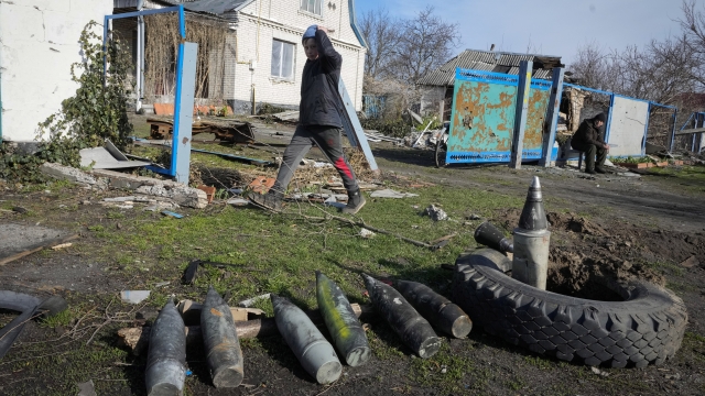 A boy walks by unexploded Russian shells in the village of Andriyivka close to Kyiv, Ukraine
