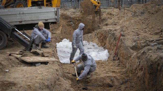 Workers dig graves in Ukraine.