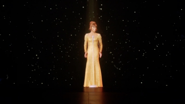 A hologram of Whitney Houston performs on stage.