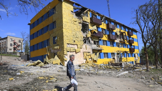 A local resident walks past a destroyed building in Mariupol.
