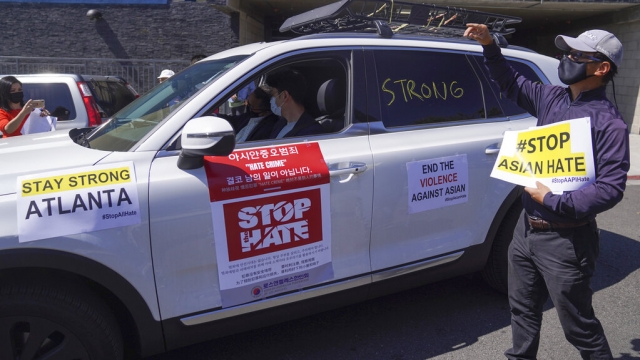 Members of the Korean American Federation of Los Angeles drive with signs reading: "#Stop Asian Hate."