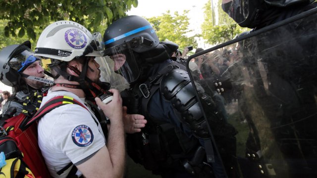 Riot policemen confront a first aid volunteer rafter clashes during a May Day demonstration.