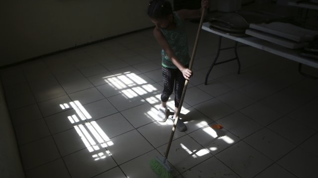A woman cleans a shelter for migrants.