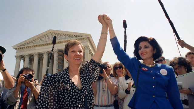 Norma McCorvey, aka Jane Roe in the 1973 court case, and her attorney Gloria Allred hold hands outside the Supreme Court