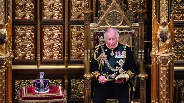 Prince Charles sits.