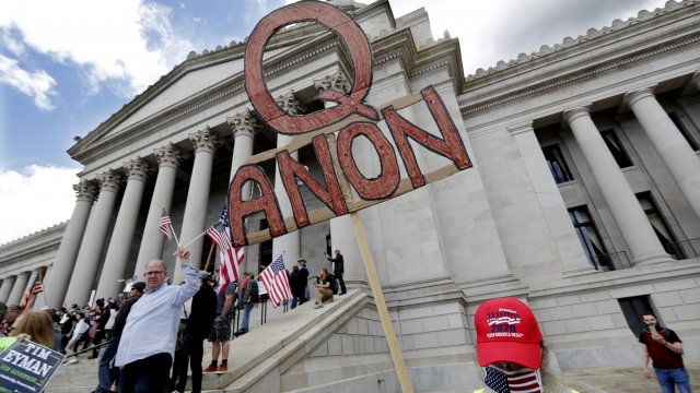 A protester holds a Q-anon sign