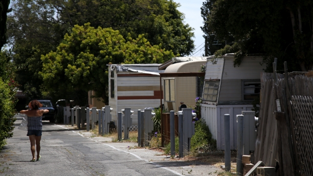 A person walks down the street in a mobile home park.