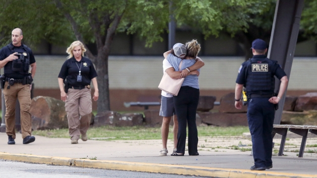 Two people hug following a shooting on a hospital campus