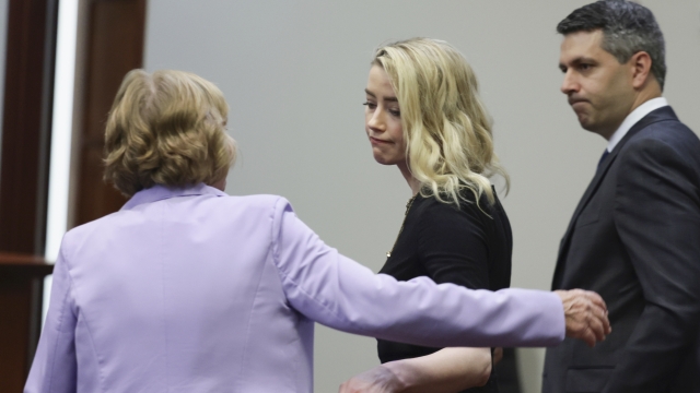 Actor Amber Heard stands with her lawyers Elaine Bredehoft and Benjamin Rottenborn after the verdict was read.