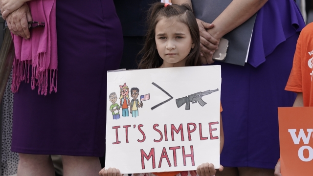 Elise Schering, 7, displays a message during a National Gun Violence Awareness Day.
