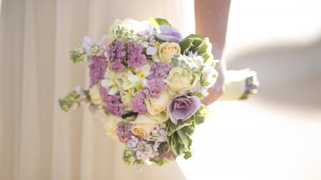 A bride holds a bouquet of flowers.