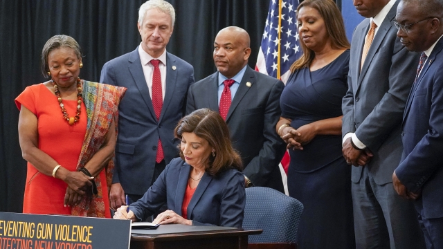 New York Gov. Kathy Hochul, center, signs a package of bills to strengthen gun laws
