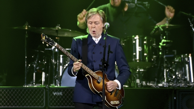 Paul McCartney performs on stage.