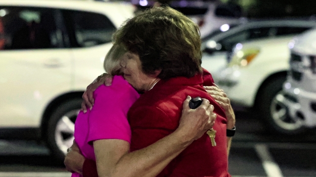 Two women hug after a church shooting.