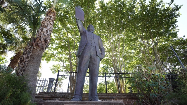 a statue depicts a man holding the state law that made Juneteenth a state holiday in Galveston, Texas