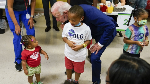 President Joe Biden speaks to a child as he visits a COVID-19 vaccination clinic.