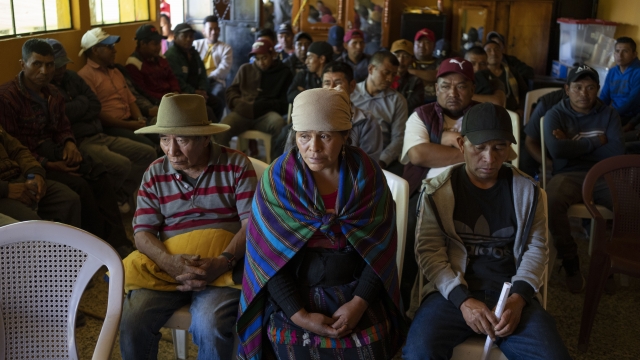 People wait for a community meeting in Guatemala.