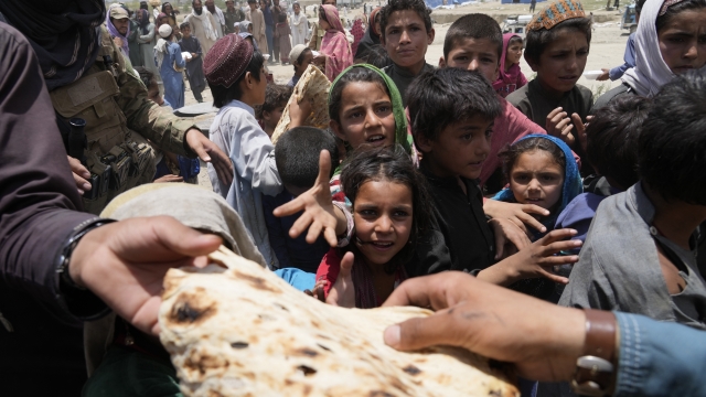 Afghans receive aid at a camp.