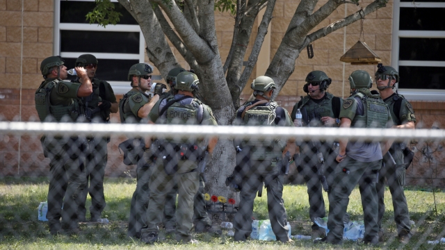 Law enforcement personnel stand outside Robb Elementary School following a shooting