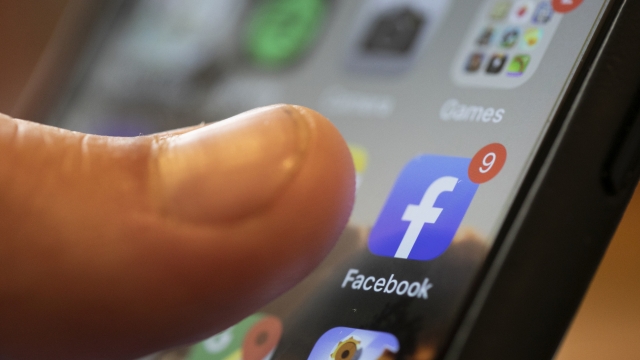 A person prepares to click the Facebook app on a smartphone.