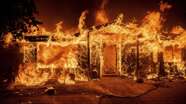 Flames consume a home on Triangle Rd. as the Oak Fire burns in Mariposa County, California.