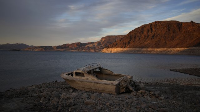 A formerly sunken boat sits high and dry along the shoreline of Lake Mead