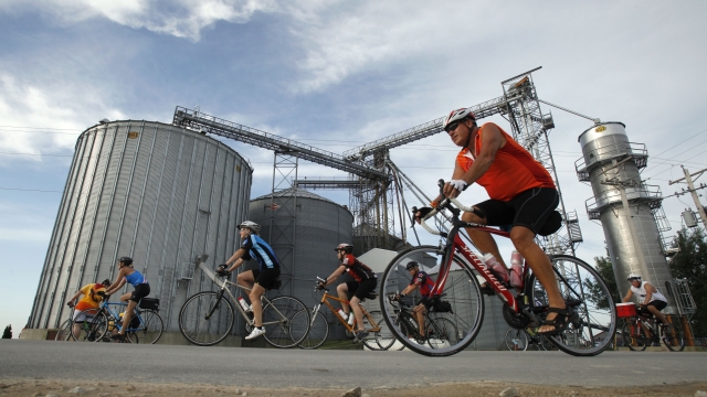 Cyclists pass a grain elevator while riding in The Des Moines Register's annual bike ride across Iowa, also know as RAGBRAI