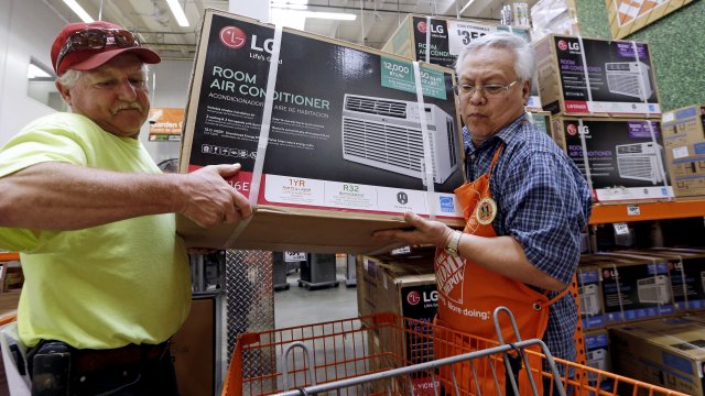 A store employee helps a customer buy an air conditioning unit.