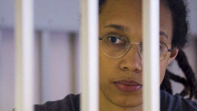 US Basketball player Brittney Griner looks through bars as she listens to the verdict standing in a cage in a courtroom