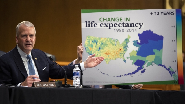 Sen. Dan Sullivan, R-Alaska, gestures to a poster about changes in life expectancy