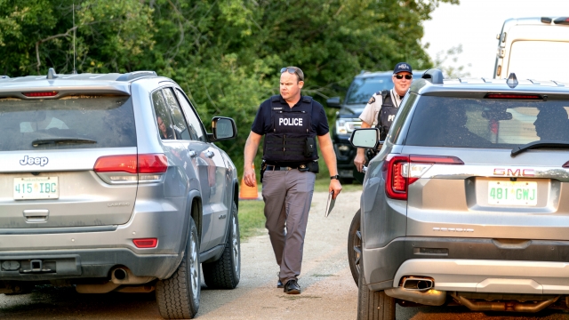 A police officer walks through the scene of a stabbing in Weldon, Saskatchewan