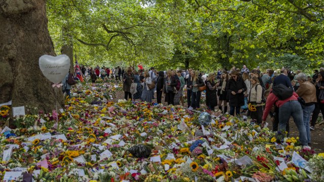 People look at flowers and messages placed for Queen Elizabeth II