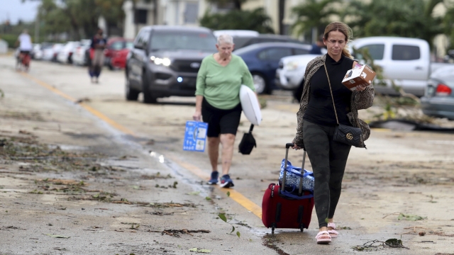 King Point residents leave with their belongings after an apparent overnight tornado spawned from Hurricane Ian