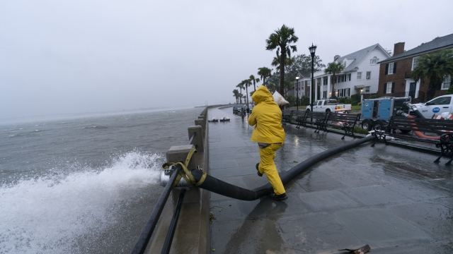 A worker moves a sandbag after a pump was placed to remove water from the Battery as the effects from Hurricane Ian are felt