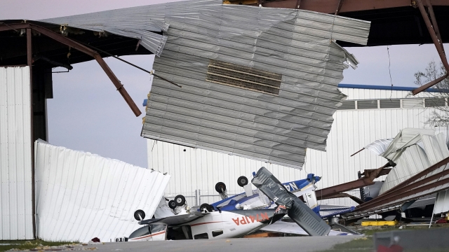 Damaged airplanes and hangars are seen.