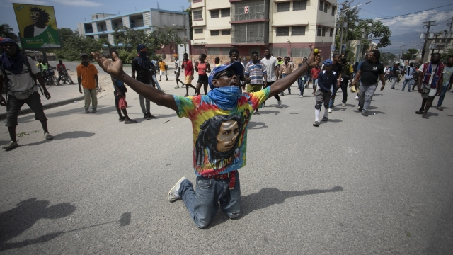 A demonstrator prays on his knees during a protest to demand the resignation of Prime Minister Ariel Henry.