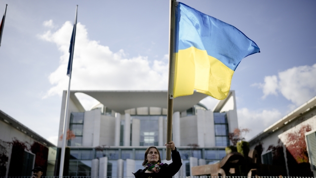 Woman waves a Ukrainian flag.