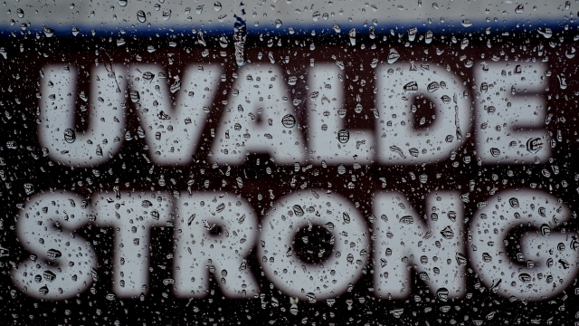 A 'Uvalde Strong' sign is seen through raindrops