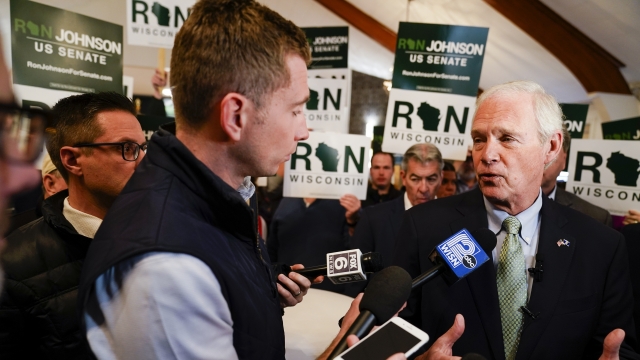 Wisconsin Republican Sen. Ron Johnson talks to reporters at a rally with supporters